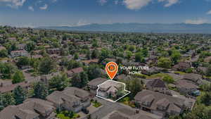 Aerial view of residential area with mountains and property boundaries highlighted