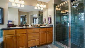 Bathroom with a stall shower, double vanity, and tile patterned flooring
