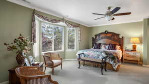 Bedroom featuring carpet floors, ornamental molding, and ceiling fan