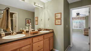 Full bath featuring double vanity and a ceiling fan