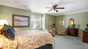 Bedroom featuring ornamental molding, carpet floors, and a ceiling fan