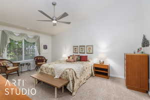 Bedroom with light colored carpet, vaulted ceiling, and a ceiling fan