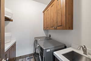 Washroom featuring cabinet space and washer and clothes dryer