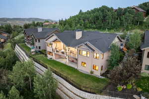 Rear view of property featuring a balcony, a fenced backyard, a patio area, and a chimney