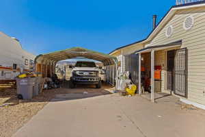 View of parking with a detached carport and driveway
