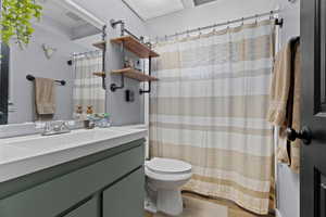Bathroom with vanity, a shower with curtain, and wood finished floors