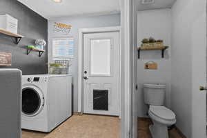 Laundry area featuring washer / dryer, a textured ceiling, and light tile patterned flooring