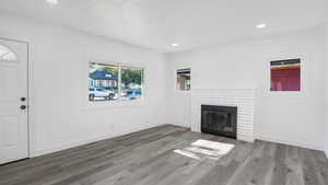 Living room with healthy amount of natural light, wood finished floors, and recessed lighting