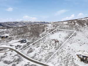 Snowy aerial view with property boundaries highlighted and a mountain view