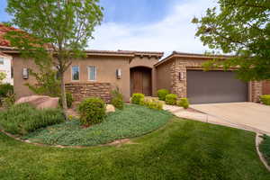 Mediterranean / spanish home with stucco siding, stone siding, driveway, a garage, and a tiled roof