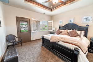 Bedroom featuring carpet, a raised ceiling, and ceiling fan