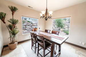 Dining space with a chandelier and baseboards