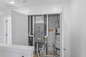 Utility room featuring water heater and heating unit