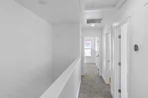 Hallway with carpet and attic access