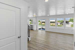Unfurnished living room featuring a textured ceiling and light wood-style flooring