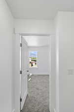 Hall featuring carpet and baseboards