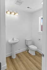 Bathroom featuring toilet and wood finished floors