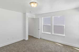 Unfurnished room featuring carpet floors and baseboards
