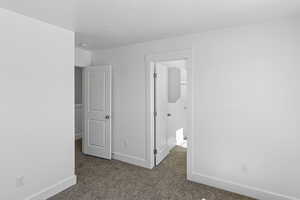 Unfurnished bedroom featuring carpet flooring and baseboards
