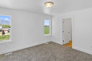 Carpeted spare room with baseboards