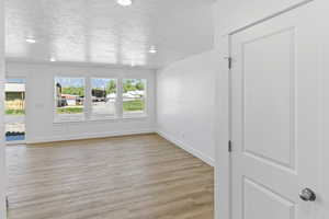 Spare room featuring a textured ceiling and light wood-style flooring