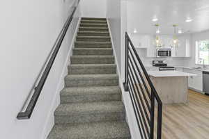 Stairway featuring wood finished floors and recessed lighting