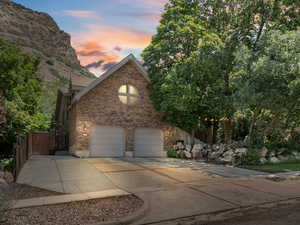View of front of house with brick siding, driveway, and an attached garage