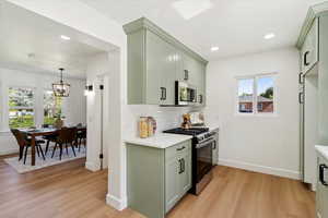 Kitchen with stainless steel appliances, green cabinetry, light countertops, and recessed lighting
