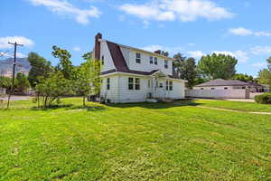 Rear view of property featuring a chimney and roof with shingles