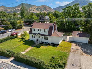 View of front of house with a chimney, a mountain view, a shingled roof, and an outdoor structure