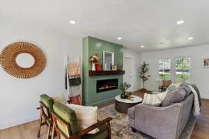 Living area featuring a large fireplace, wood finished floors, and recessed lighting