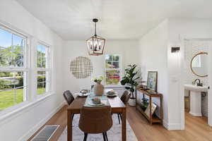 Dining area featuring a chandelier, healthy amount of natural light, and light wood-style flooring