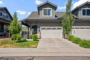Craftsman house featuring board and batten siding, concrete driveway, an attached garage, covered porch, and a shingled roof