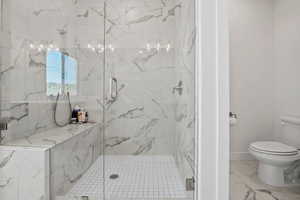 Full bath with a marble finish shower and marble finish floors