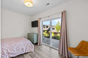 Bedroom with access to exterior and light wood-style floors