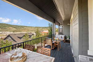 Wooden terrace with an outdoor living space, a mountain view, and outdoor dining area