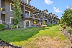 View of grassy yard with a balcony