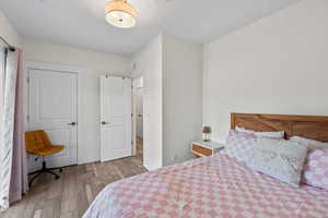 Bedroom with wood finished floors and baseboards