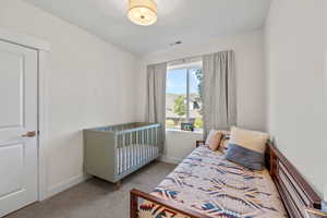 Bedroom with carpet floors and a crib