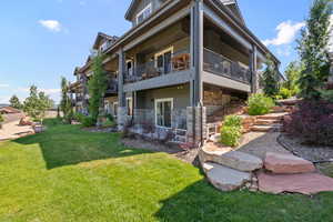 View of side of home featuring a balcony and a lawn