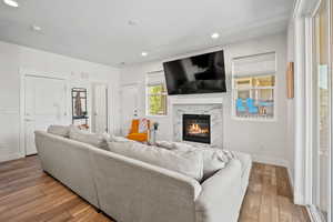 Living area featuring wood-type flooring, a high end fireplace, and recessed lighting