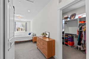Carpeted bedroom with a closet, attic access, and recessed lighting