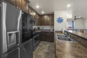Kitchen featuring appliances with stainless steel finishes, dark countertops, dark brown cabinetry, ceiling fan, and recessed lighting