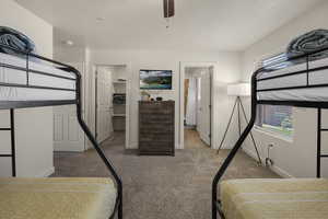 Bedroom featuring carpet floors, a spacious closet, and a ceiling fan