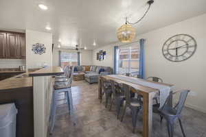 Dining space with a chandelier, tile patterned floors, and recessed lighting