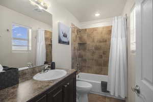 Full bathroom featuring vanity, shower / bathtub combination with curtain, and tile patterned flooring