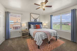 Carpeted bedroom featuring multiple windows and a ceiling fan