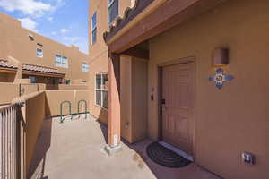 Entrance to property with stucco siding and a balcony