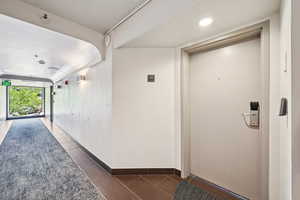 Hall featuring tile patterned flooring and baseboards