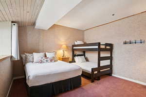 Bedroom featuring wallpapered walls and carpet flooring